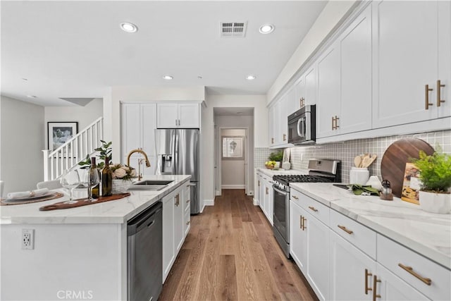 166 Borrego, Irvine, CA 92618 - kitchen featuring stainless steel appliances, a sink, white cabinetry, tasteful backsplash, and recessed lighting