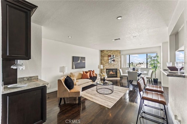 1436 257th St Unit 303, Harbor City, CA 90710 - living area featuring a textured ceiling, a fireplace, dark wood-type flooring, recessed lighting, and baseboards