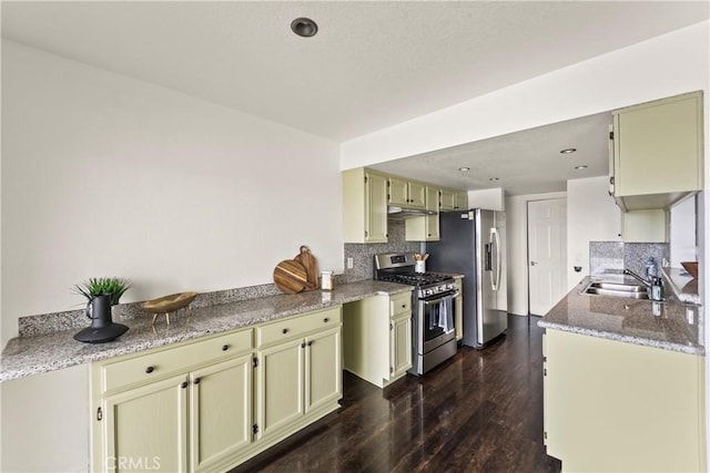 1436 257th St Unit 303, Harbor City, CA 90710 - kitchen with appliances with stainless steel finishes, a sink, decorative backsplash, dark wood-style floors, and light stone counters