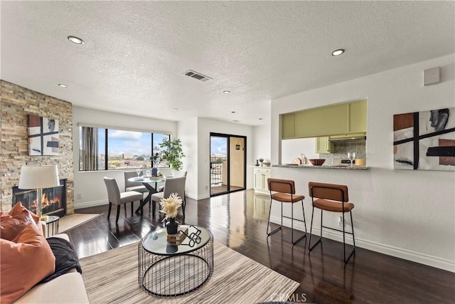 1436 257th St Unit 303, Harbor City, CA 90710 - living area featuring a textured ceiling, wood finished floors, baseboards, a stone fireplace, and recessed lighting