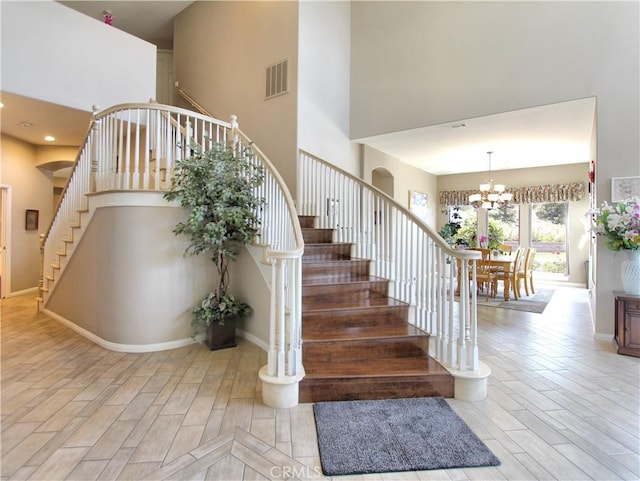 12949 Pinewood Ln, Yucaipa, CA 92399 - stairs featuring a high ceiling, a chandelier, wood finished floors, and baseboards