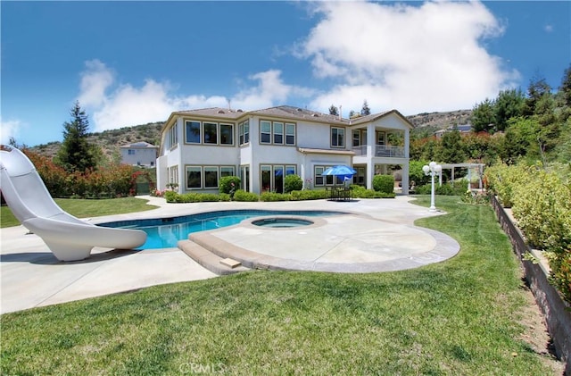 12949 Pinewood Ln, Yucaipa, CA 92399 - swimming pool featuring a water slide, an in-ground hot tub, a patio, and a lawn