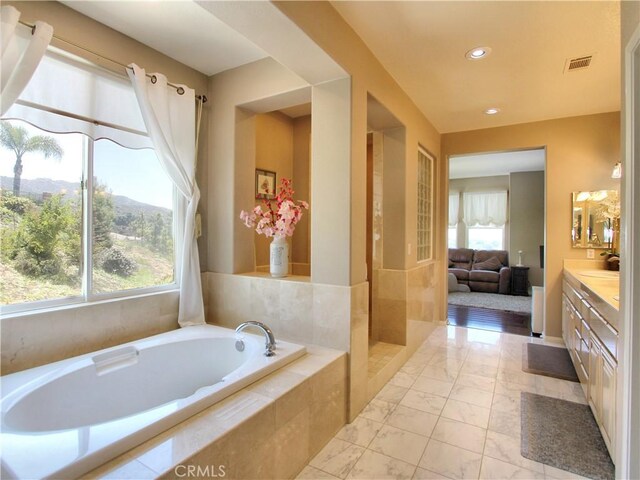 12949 Pinewood Ln, Yucaipa, CA 92399 - bathroom featuring vanity, a bath, marble look tiles, and recessed lighting