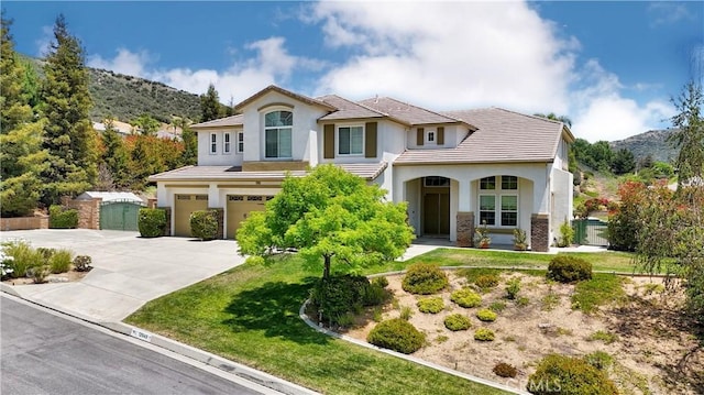 12949 Pinewood Ln, Yucaipa, CA 92399 - view of front facade with an attached garage, stucco siding, concrete driveway, and a mountain view