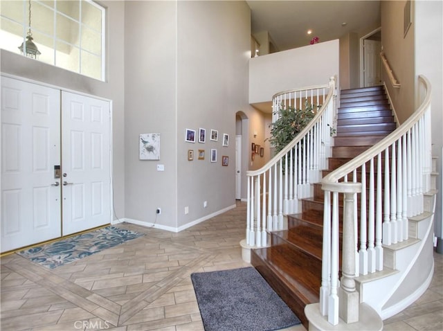 12949 Pinewood Ln, Yucaipa, CA 92399 - entryway with a high ceiling, baseboards, arched walkways, and stairway