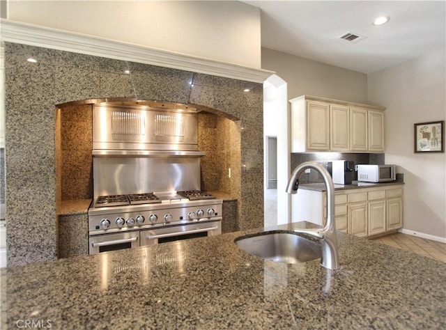 12949 Pinewood Ln, Yucaipa, CA 92399 - kitchen featuring cream cabinetry, white microwave, a sink, tasteful backsplash, and double oven range