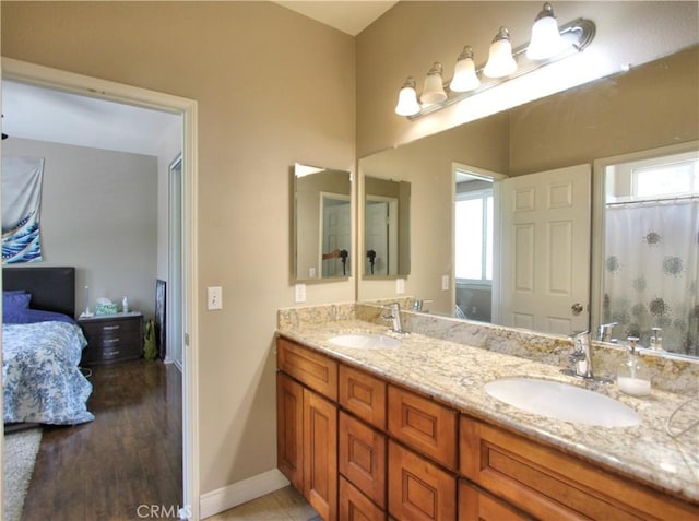 12949 Pinewood Ln, Yucaipa, CA 92399 - ensuite bathroom with double vanity, healthy amount of natural light, baseboards, and wood finished floors