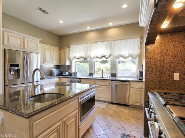 12949 Pinewood Ln, Yucaipa, CA 92399 - kitchen with appliances with stainless steel finishes, a sink, tasteful backsplash, an island with sink, and recessed lighting