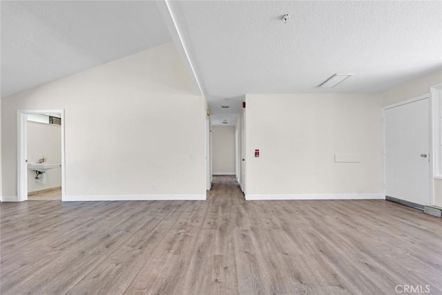 2472 Forbes Ave, Claremont, CA 91711 - unfurnished living room featuring light wood finished floors, a textured ceiling, baseboards, and lofted ceiling