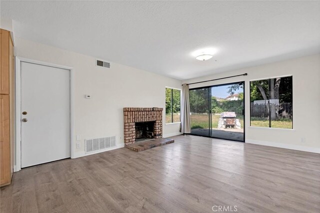 2472 Forbes Ave, Claremont, CA 91711 - unfurnished living room featuring light wood-style flooring, baseboards, and a brick fireplace