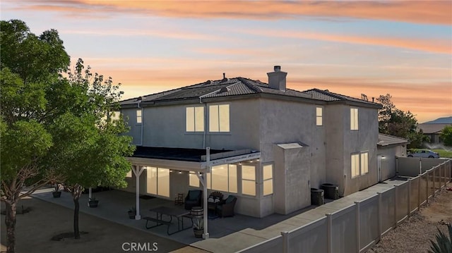 6688 Banyan Ave, Hesperia, CA 92345 - rear view of property featuring a patio, a chimney, a fenced backyard, stucco siding, and a tile roof