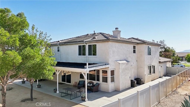 6688 Banyan Ave, Hesperia, CA 92345 - back of property featuring a patio, a chimney, a fenced backyard, and stucco siding