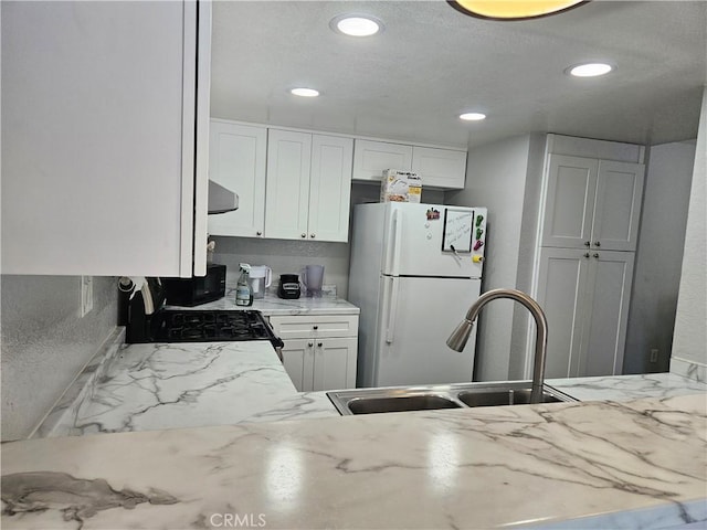 3532 W Stonepine Ln Unit B, Anaheim, CA 92804 - kitchen with freestanding refrigerator, a sink, gas stove, recessed lighting, and white cabinetry