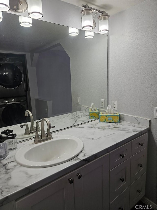 3532 W Stonepine Ln Unit B, Anaheim, CA 92804 - bathroom with stacked washer / drying machine, vanity, and a textured wall
