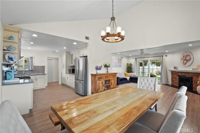 1420 Bookman Ave, Walnut, CA 91789 - dining space with a chandelier, light wood-style floors, a fireplace, ceiling fan, and recessed lighting