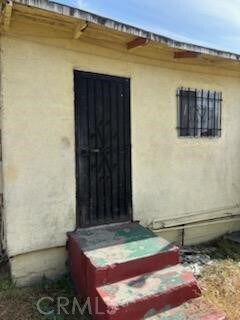 1413 E 77th St, Los Angeles, CA 90001 - view of exterior entry featuring stucco siding