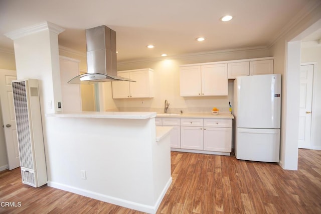 1207 S L St, Oxnard, CA 93033 - kitchen with freestanding refrigerator, a heating unit, crown molding, light countertops, and exhaust hood