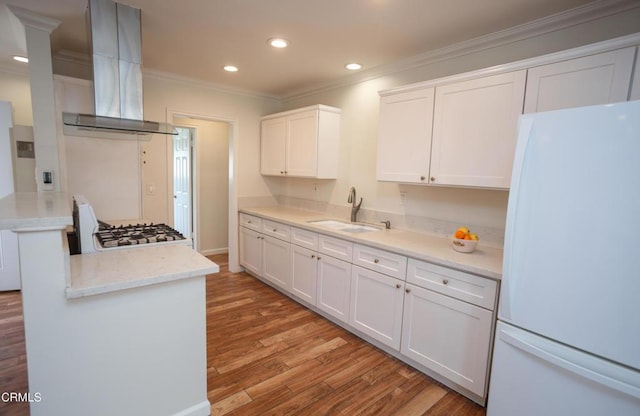 1207 S L St, Oxnard, CA 93033 - kitchen with freestanding refrigerator, wall chimney exhaust hood, crown molding, white cabinetry, and light wood-style floors