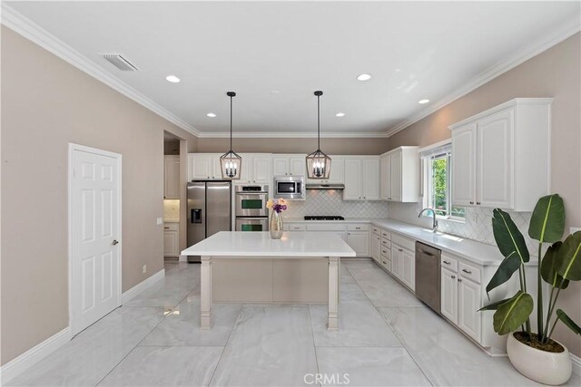 8851 Soothing Ct, Corona, CA 92883 - kitchen featuring stainless steel appliances, white cabinets, backsplash, light countertops, and a center island