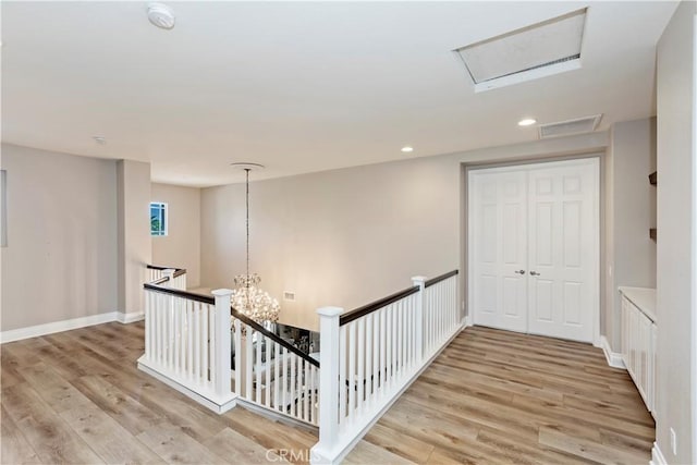 8851 Soothing Ct, Corona, CA 92883 - corridor featuring attic access, an upstairs landing, light wood finished floors, a chandelier, and recessed lighting