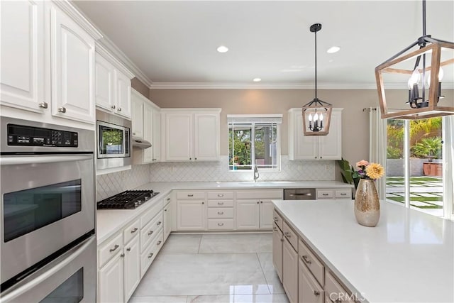 8851 Soothing Ct, Corona, CA 92883 - kitchen with stainless steel appliances, a chandelier, tasteful backsplash, white cabinets, and crown molding