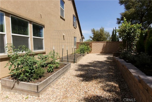 24649 Round Meadow Dr, Menifee, CA 92584 - view of side of home featuring stucco siding and a garden