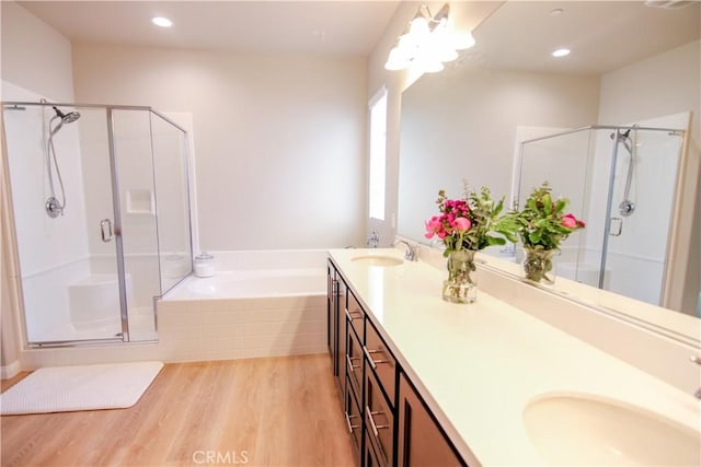 24649 Round Meadow Dr, Menifee, CA 92584 - bathroom with a shower stall, wood finished floors, a garden tub, double vanity, and recessed lighting