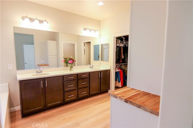 24649 Round Meadow Dr, Menifee, CA 92584 - bathroom with double vanity, wood finished floors, a walk in closet, and recessed lighting