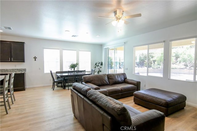 24649 Round Meadow Dr, Menifee, CA 92584 - living room featuring plenty of natural light, light wood-style floors, a ceiling fan, and baseboards