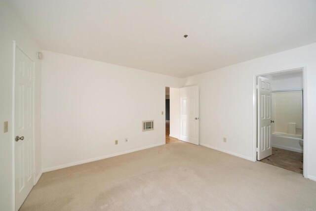 7753 Caminito Encanto Unit 102, Carlsbad, CA 92009 - unfurnished bedroom with light colored carpet, baseboards, and connected bathroom