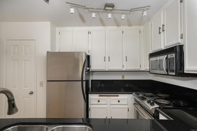 7753 Caminito Encanto Unit 102, Carlsbad, CA 92009 - kitchen with stainless steel appliances, dark countertops, a sink, and white cabinetry