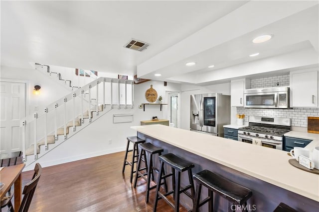 31342 Silverado Canyon Rd, Silverado Canyon, CA 92676 - kitchen featuring stainless steel appliances, baseboards, decorative backsplash, light countertops, and dark wood-style flooring