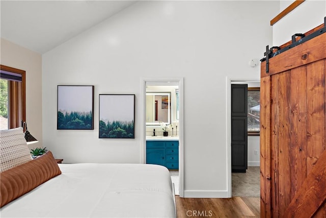 31342 Silverado Canyon Rd, Silverado Canyon, CA 92676 - bedroom with wood finished floors, high vaulted ceiling, a barn door, and connected bathroom