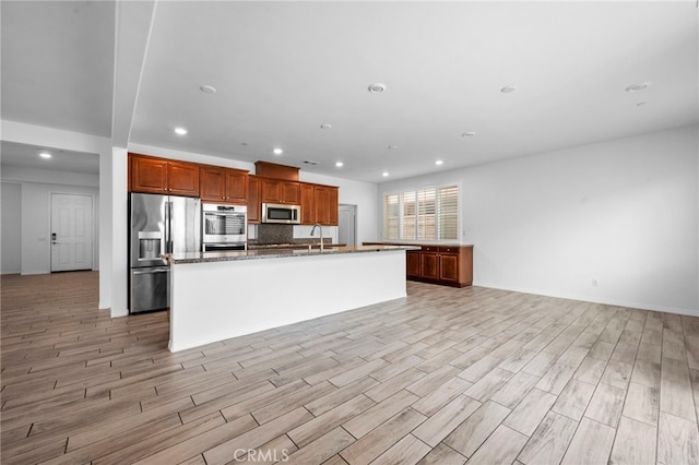 6864 Ripple Ct, Jurupa Valley, CA 91752 - kitchen with stainless steel appliances, a sink, light wood-type flooring, recessed lighting, and a kitchen island with sink