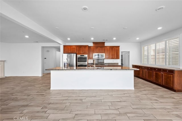 6864 Ripple Ct, Jurupa Valley, CA 91752 - kitchen featuring appliances with stainless steel finishes, a large island, dark stone countertops, recessed lighting, and light wood finished floors