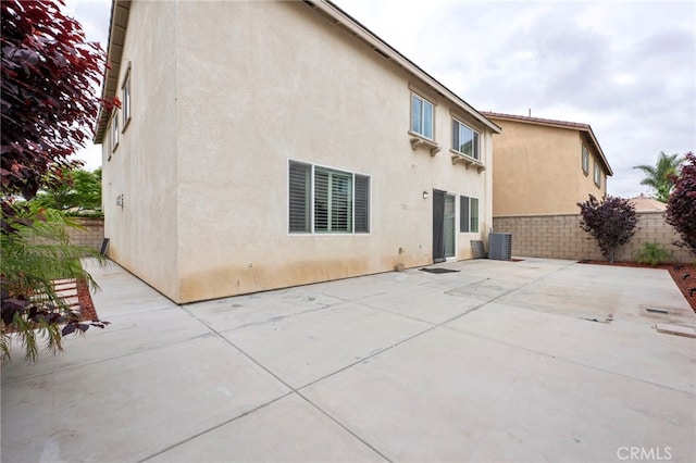 6864 Ripple Ct, Jurupa Valley, CA 91752 - rear view of house with stucco siding, a patio area, and central AC