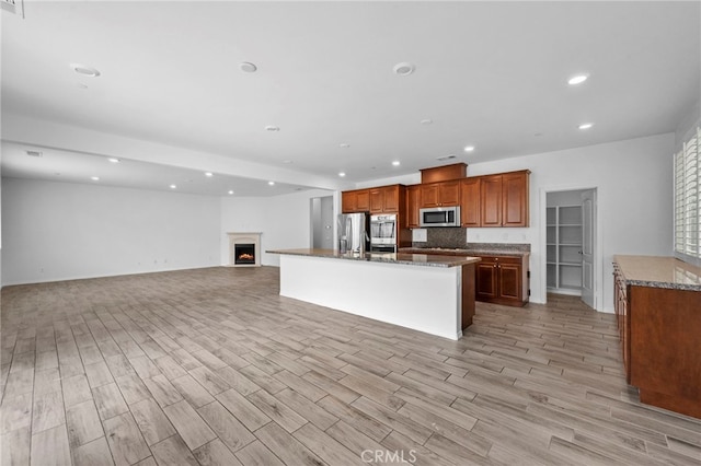 6864 Ripple Ct, Jurupa Valley, CA 91752 - kitchen featuring stainless steel appliances, light wood-style floors, open floor plan, recessed lighting, and a kitchen island with sink