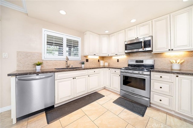 11015 Charleston St, Rancho Cucamonga, CA 91701 - kitchen featuring appliances with stainless steel finishes, a sink, backsplash, dark stone counters, and white cabinets