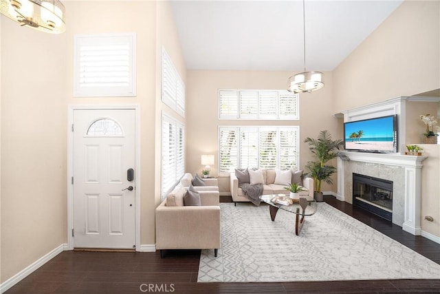 11015 Charleston St, Rancho Cucamonga, CA 91701 - living room featuring a chandelier, a towering ceiling, dark wood-style flooring, baseboards, and a high end fireplace