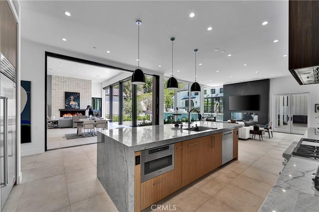 25057 Lewis And Clark Rd, Hidden Hills, CA 91302 - kitchen featuring open floor plan, a sink, appliances with stainless steel finishes, light stone counters, and healthy amount of natural light