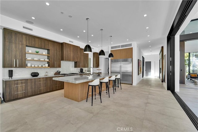 25057 Lewis And Clark Rd, Hidden Hills, CA 91302 - kitchen with built in fridge, modern cabinets, tasteful backsplash, a spacious island, and recessed lighting