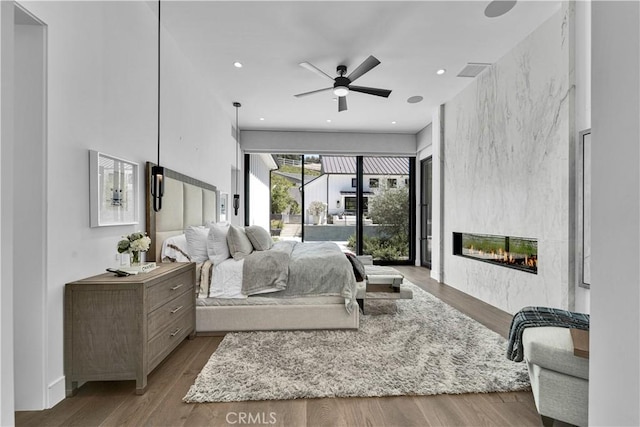 25057 Lewis And Clark Rd, Hidden Hills, CA 91302 - bedroom with access to exterior, a fireplace, wood finished floors, and recessed lighting