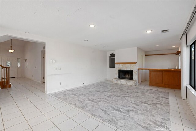 2207 Inverness Ct, Oxnard, CA 93036 - unfurnished living room featuring light tile patterned flooring, light colored carpet, recessed lighting, a fireplace with raised hearth, and baseboards