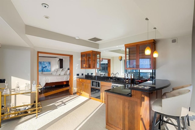 200 Harbor Dr Unit 1502, San Diego, CA 92101 - kitchen featuring stainless steel microwave, dark countertops, a sink, and brown cabinets