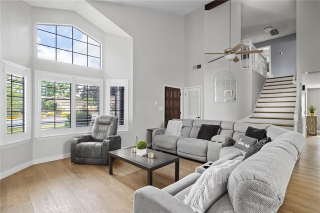 7209 Copper Creek Way, Bakersfield, CA 93308 - living room featuring a towering ceiling, ceiling fan, stairs, wood finished floors, and baseboards