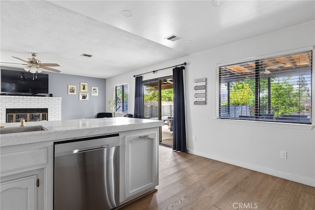 7209 Copper Creek Way, Bakersfield, CA 93308 - kitchen featuring stainless steel dishwasher, light wood-style floors, a ceiling fan, baseboards, and a textured ceiling