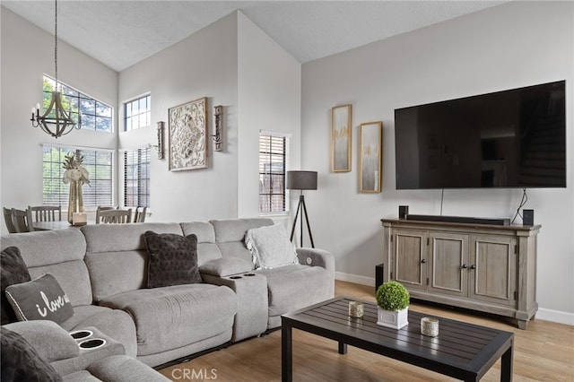 7209 Copper Creek Way, Bakersfield, CA 93308 - living room with a chandelier, light wood-style floors, baseboards, and a high ceiling