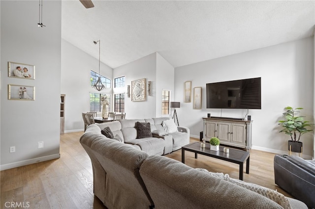 7209 Copper Creek Way, Bakersfield, CA 93308 - living room with light wood finished floors, a high ceiling, baseboards, and a chandelier