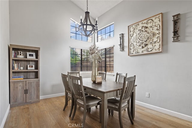 7209 Copper Creek Way, Bakersfield, CA 93308 - dining space featuring a chandelier, wood finished floors, high vaulted ceiling, and baseboards