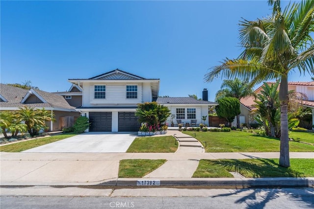 17392 Almelo Ln, Huntington Beach, CA 92649 - view of front facade featuring an attached garage, a front lawn, concrete driveway, stucco siding, and a tiled roof